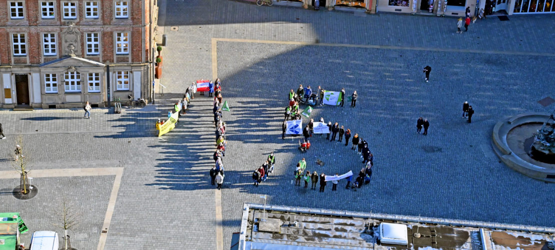 Klimakundgebung – Etwa 80 Teilnehmerinnen und Teilnehmer bildeten auf dem Paderborner Domplatz eine „menschliche 1,5“, um die Ziele des Pariser Klimaabkommens zu bekräftigen.￼ (Foto: Patrick Kleibold)