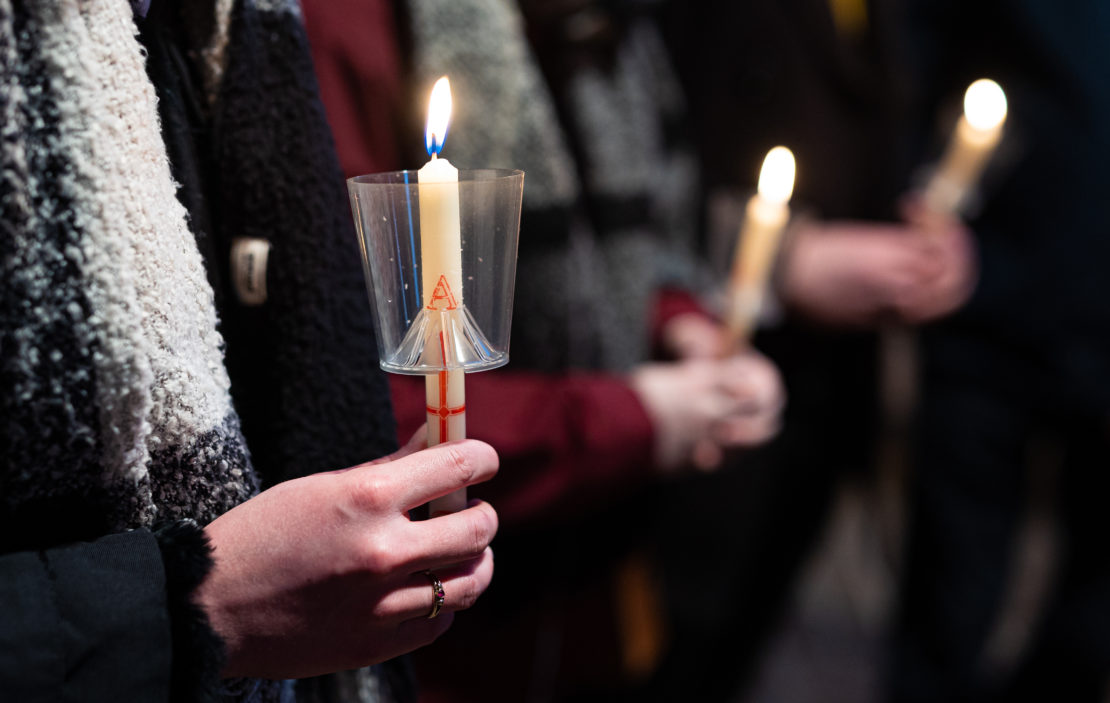 Gläubige halten bei einem Friedensgebet anlässlich des Angriffs Russlands auf die Ukraine Kerzen in ihren Händen.