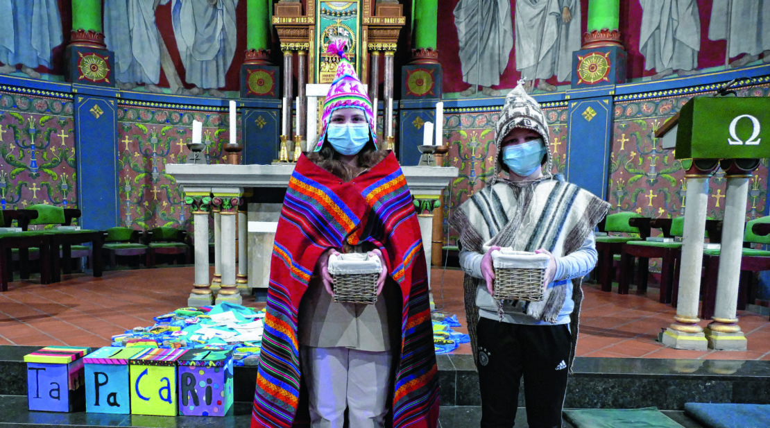 Bolivienwoche – Zeichen der Hoffnung und Solidarität: Alina Gnasty­schak und Lukas Zwick in indigener Kleidung mit der Kollekte für das Internat in Tapacari. (Foto: St. Xaver)