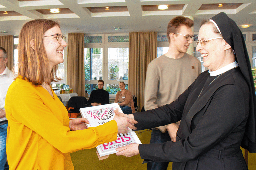 Christina Menke aus der Bildungsakademie für Therapieberufe nimmt für die „Bigger Jugend“ aus den Händen der Generaloberin Schwester Maria Thoma Dikow die Urkunde für den ersten Platz entgegen.