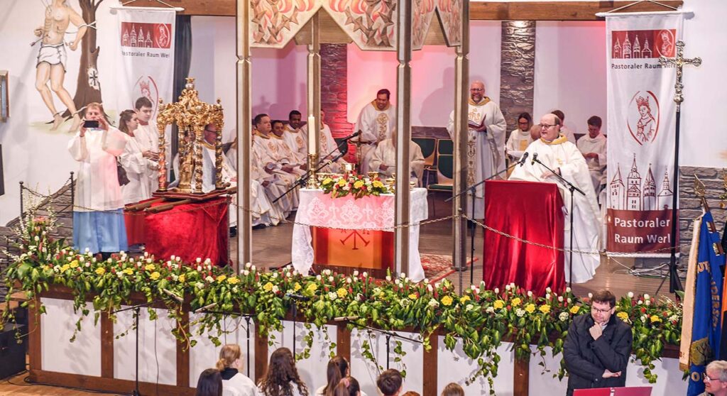Der festlich geschmückte Altarraum in der Schützenhalle. Propst Michael Feldmann aus Werl (am Ambo) ist der Leiter des pastoralen Raumes.