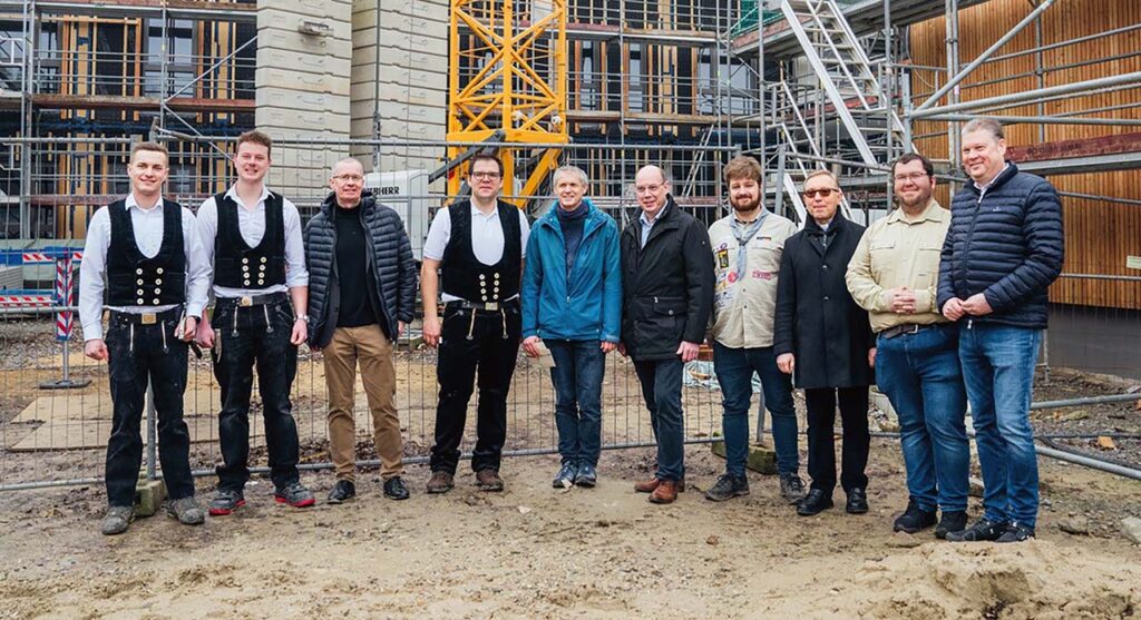 Zimmerleute, Diözesanvorstand und Geschäftsführer, politische und kirchliche Vertreter vor dem ­Neubau.
